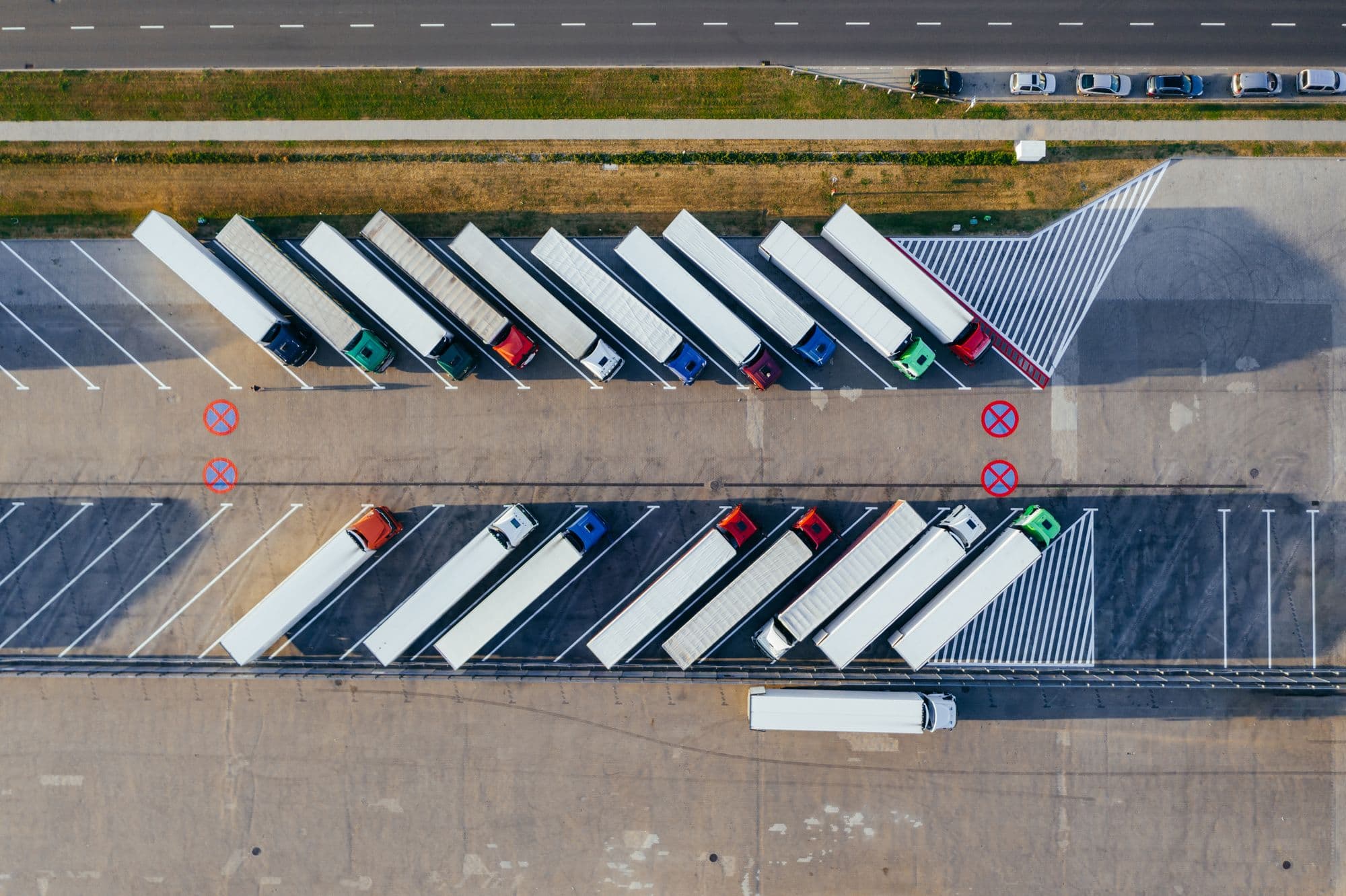 Aerial view of tractor-trailers parked in rows in a carrier's yard